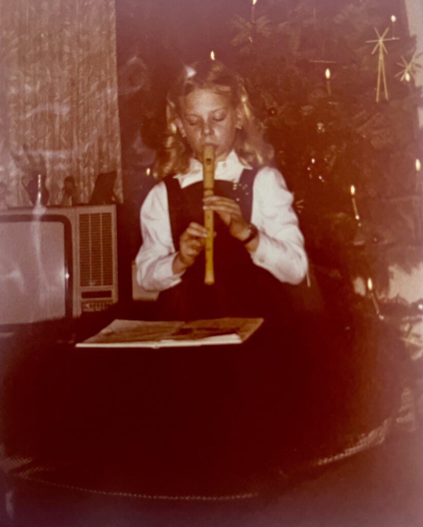 Karina als 7-jährige beim Flöten spielen an Weihnachten